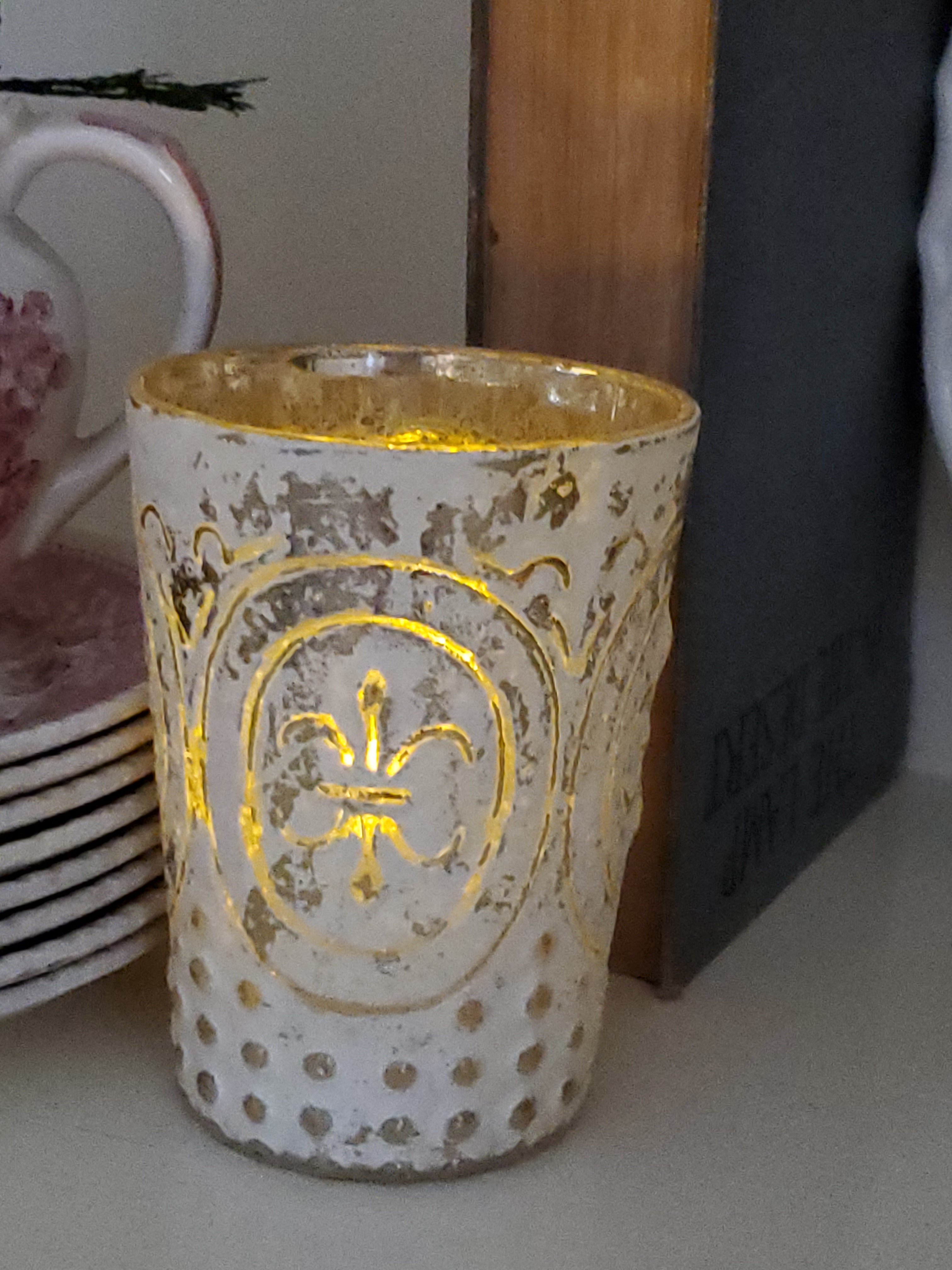 a white votive jar filled with a votve candle