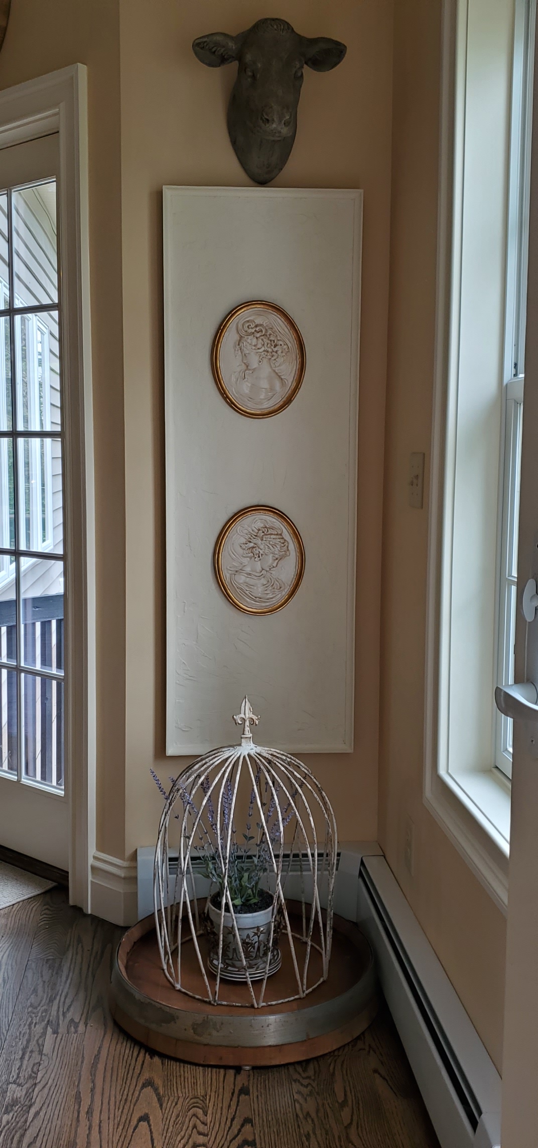 craft project on the floor on a wine barrel inside a large metal cloche. Under pictures and a cow head