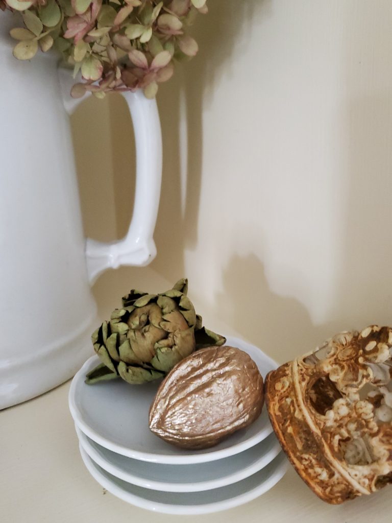walnut in the shell, dried artichoke and small crown