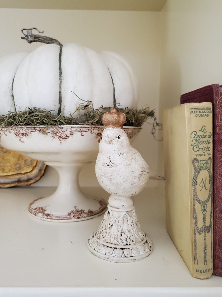a bird with a gold crown nd antique books