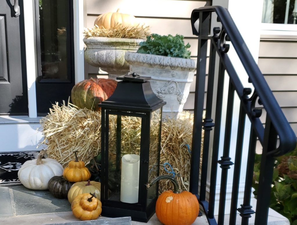 the other side of the porch with pumpkins and black lantern