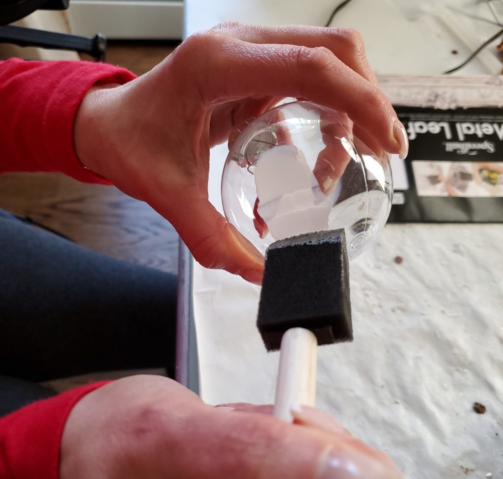 adding leaf adhesive for the silver leaf on the balls