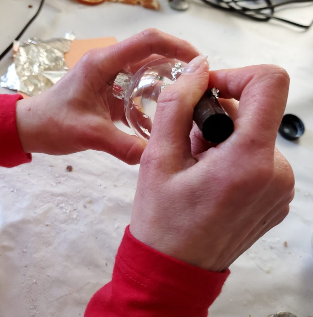 smoothing the silver leaf with a brush