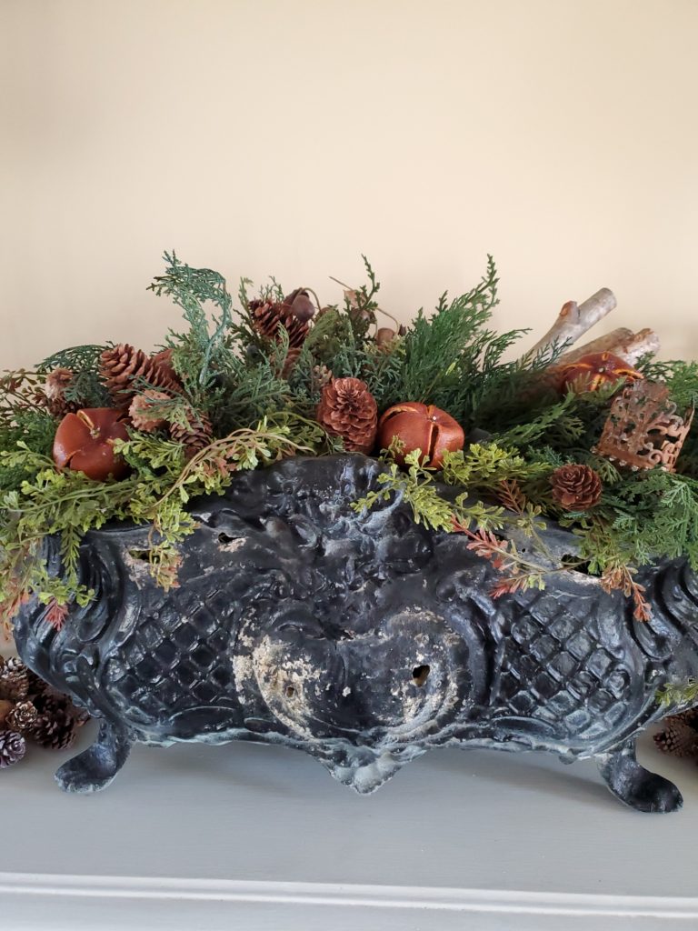 Buffet in Christmas Great room with a jardiniere filled with pine and citrus