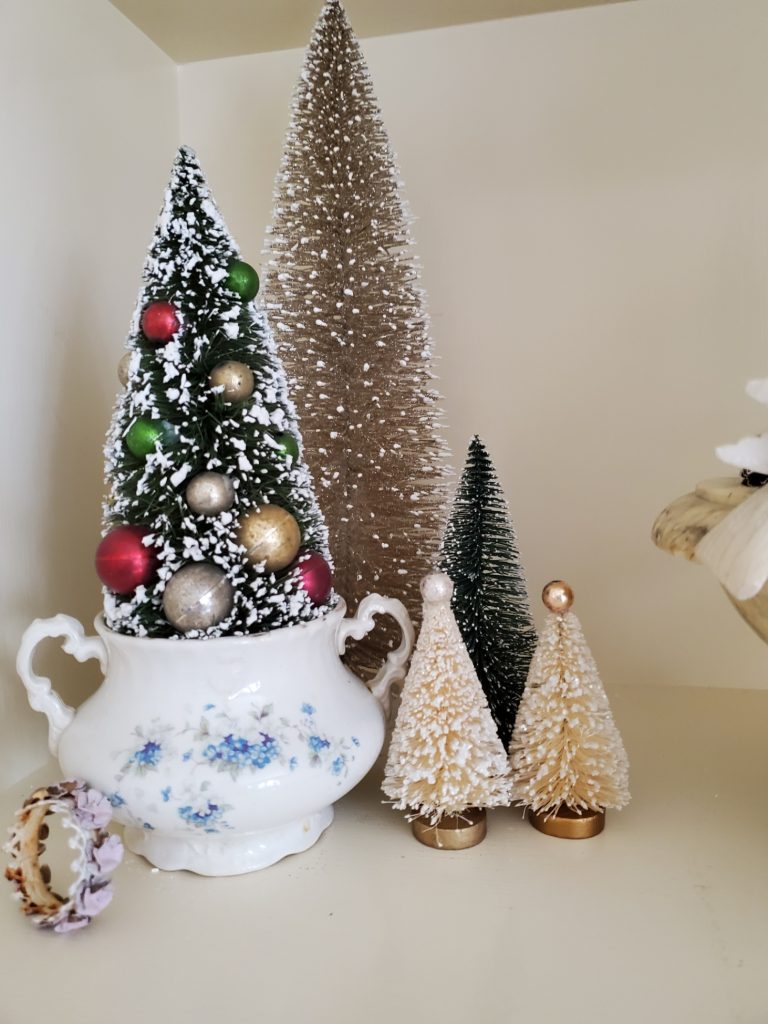 close up of bottle brush trees on the bookcase for Christmas Great Room