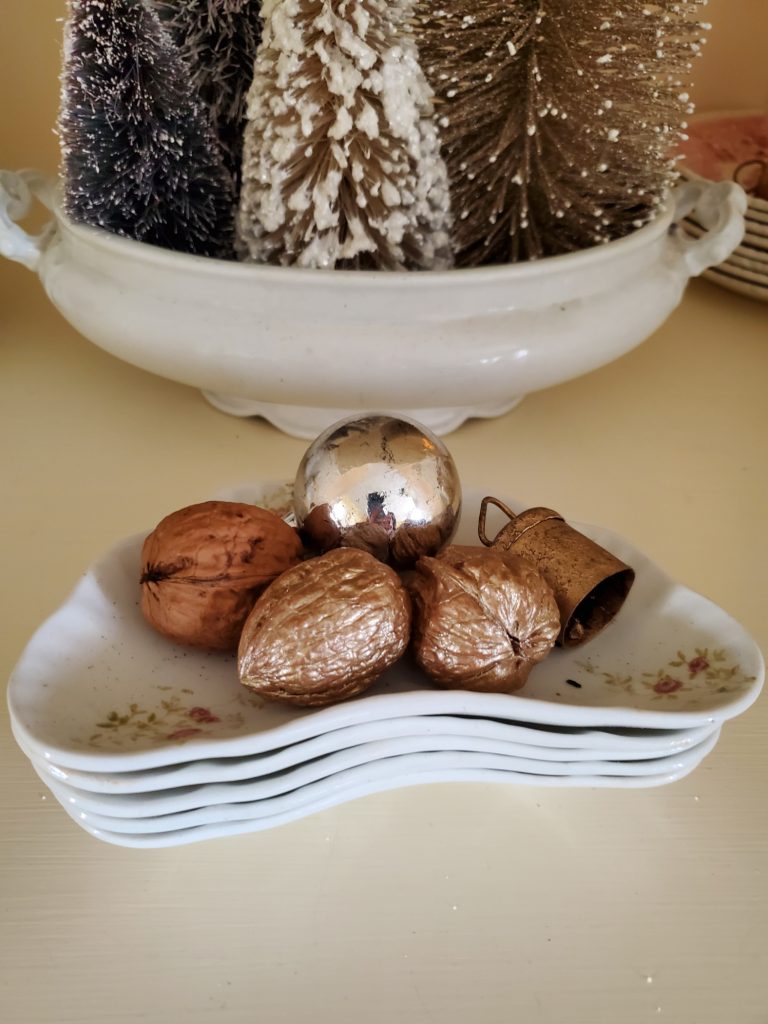 gold and champagne color walnuts with a bell on small dishes