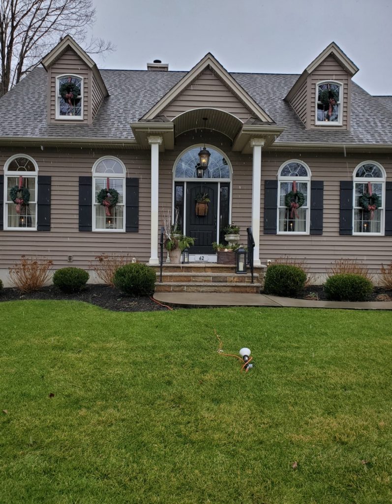 a picture of the entire house with wreathes hanging from each window