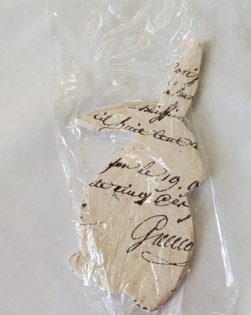 using plastic wrap to remove any wrinkles from the rabbit after decoupaging