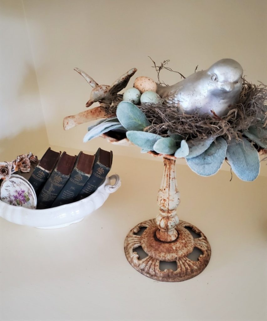 a silver bird sitting on a nest