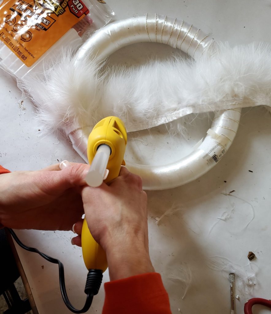 Adding glue to the fur trim as I am adding it to the Christmas wreath
