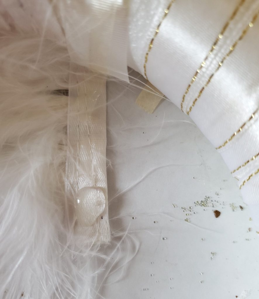 Drop of glue to glue the last wrap of the trim with satin to the wreath