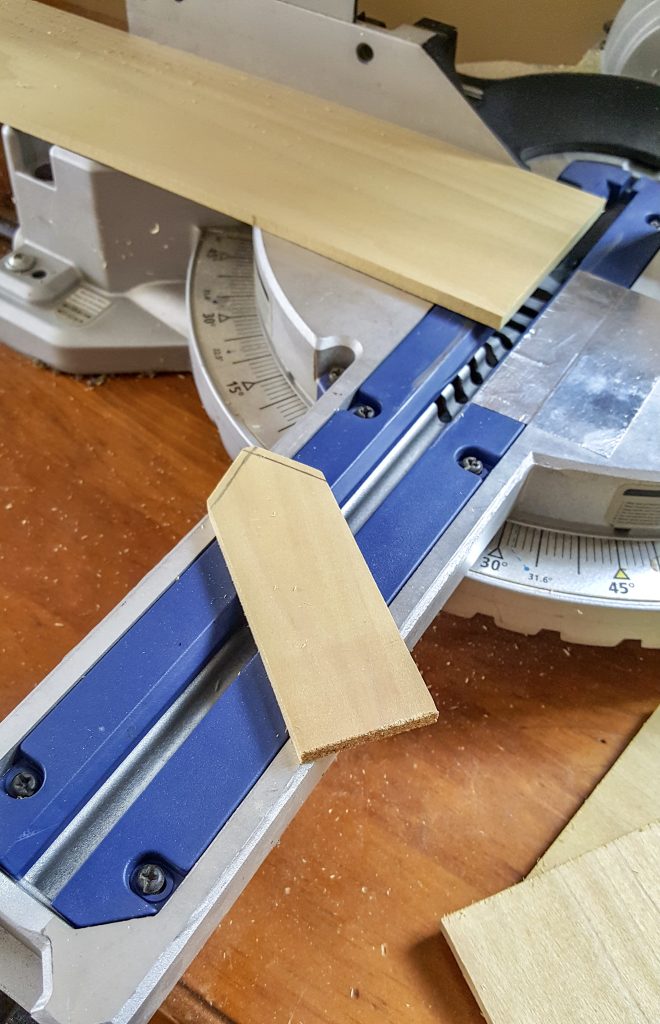 Wood getting cut to shape of a tag