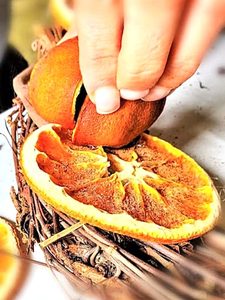 dried-orange-wreath-with-natural-decorations-me-holding-orange-to-set