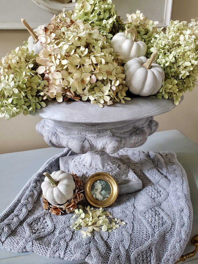 Urn filled with hydrangeas, small pumpkins for a country look
