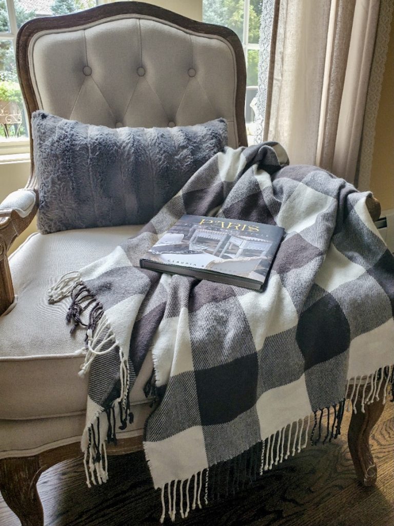 chair with fur pillow and a book and throw for a rustic home