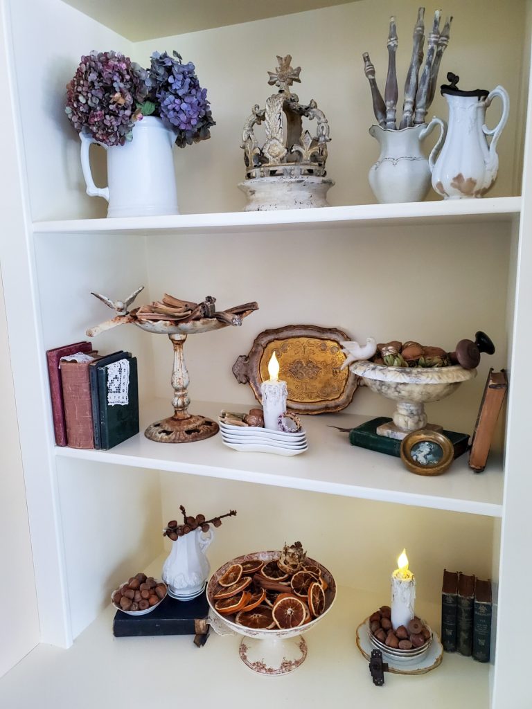 fall decor on the bookcase. showing the candles lit
doorknobs, old books and fall decor