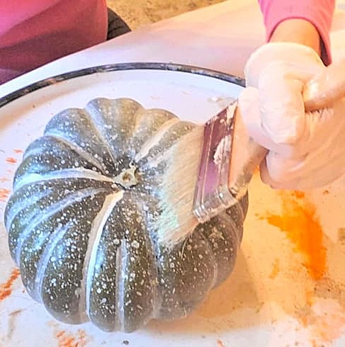 chalk-paint-on-pumpkins-is-a-sustainable-choice-me-dry brushing light green paint