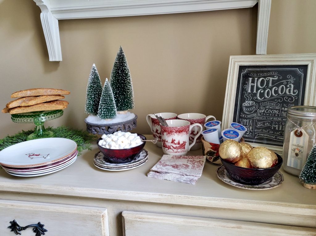 A full view of the hot choclate bar

Bottle brush trees with snow re on a pedestal.

Biscotti on a  cake plate, coccoa bombs on a bowl alongside marshmallows
