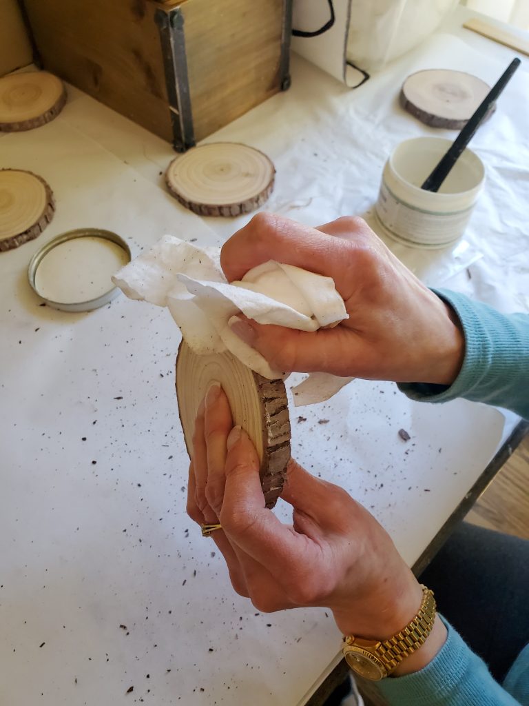 Wiping the white wax in the bark on the wood coasters