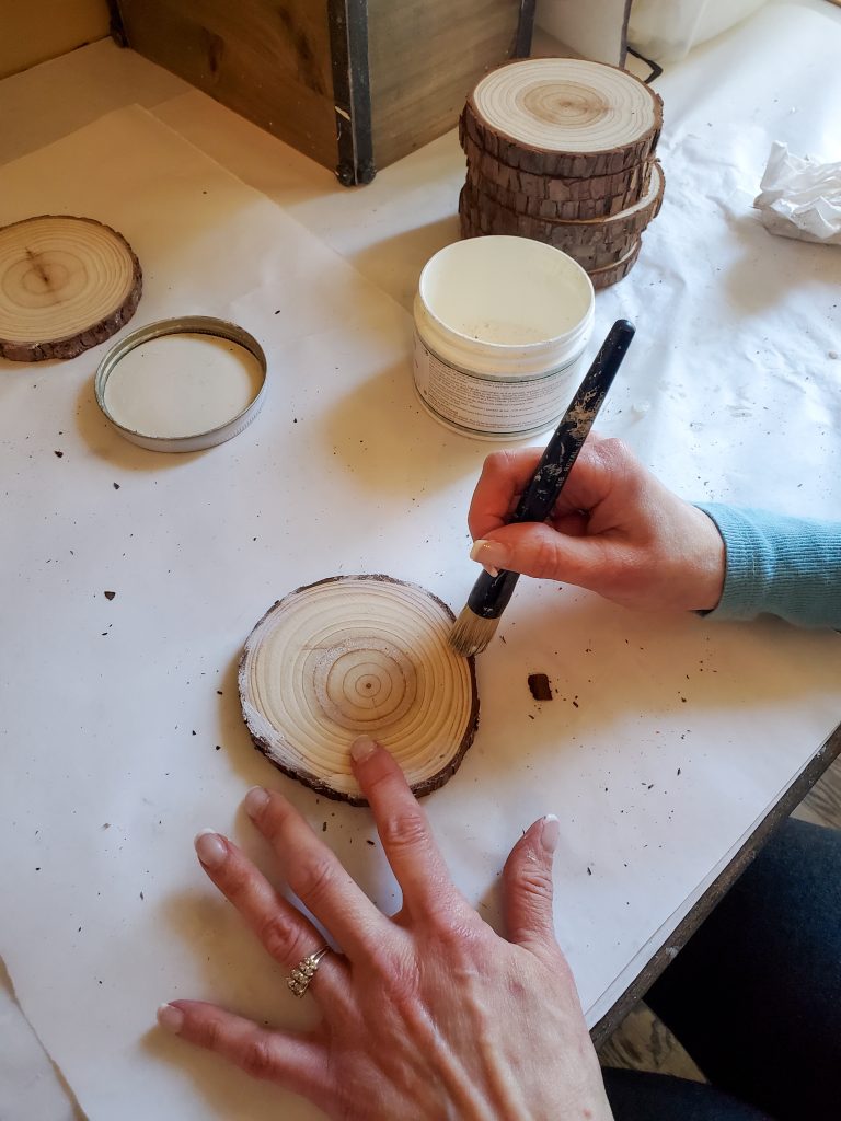 adding white wax to the edge of the top of the DIY wood coaster