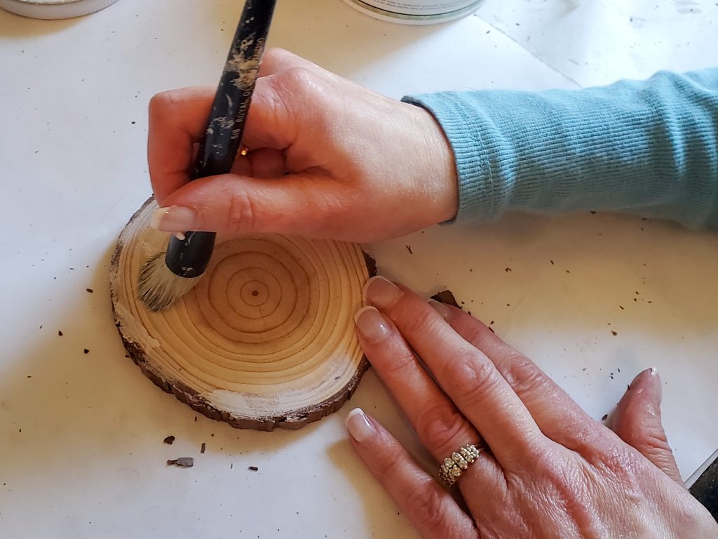 adding white wax to the flat top of the wood on the DIY coasters