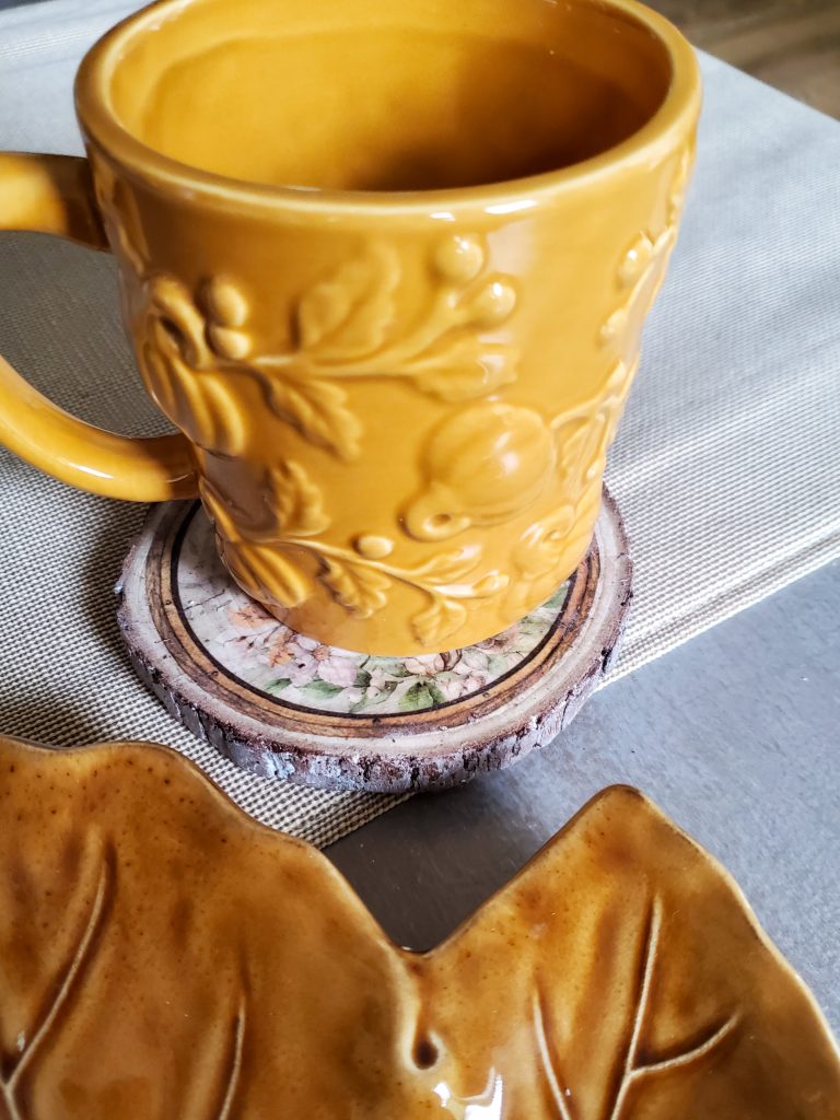 a mug with pumpkins on it sitting on the wood coaster