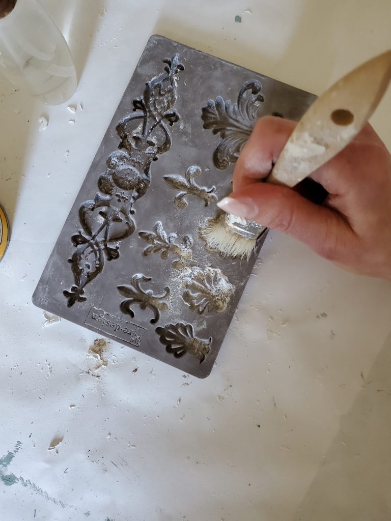 adding cornstarch to the molds with a brush