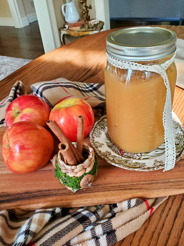 applesauce in a pretty Mason jar with apples and Cinnamon sticks
