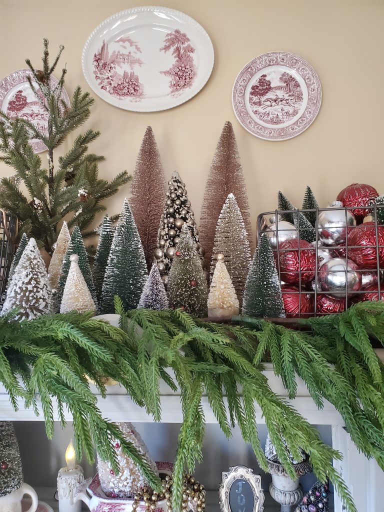 the other side of the hutch top with a metal basket filled with silver and red ornaments and bottle brush trees