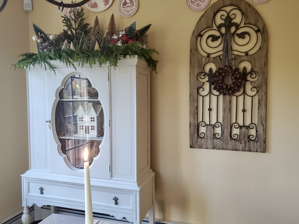 picture of my hutch decorated for vintage french christmas.
An antique shutter with a pinecone wreath