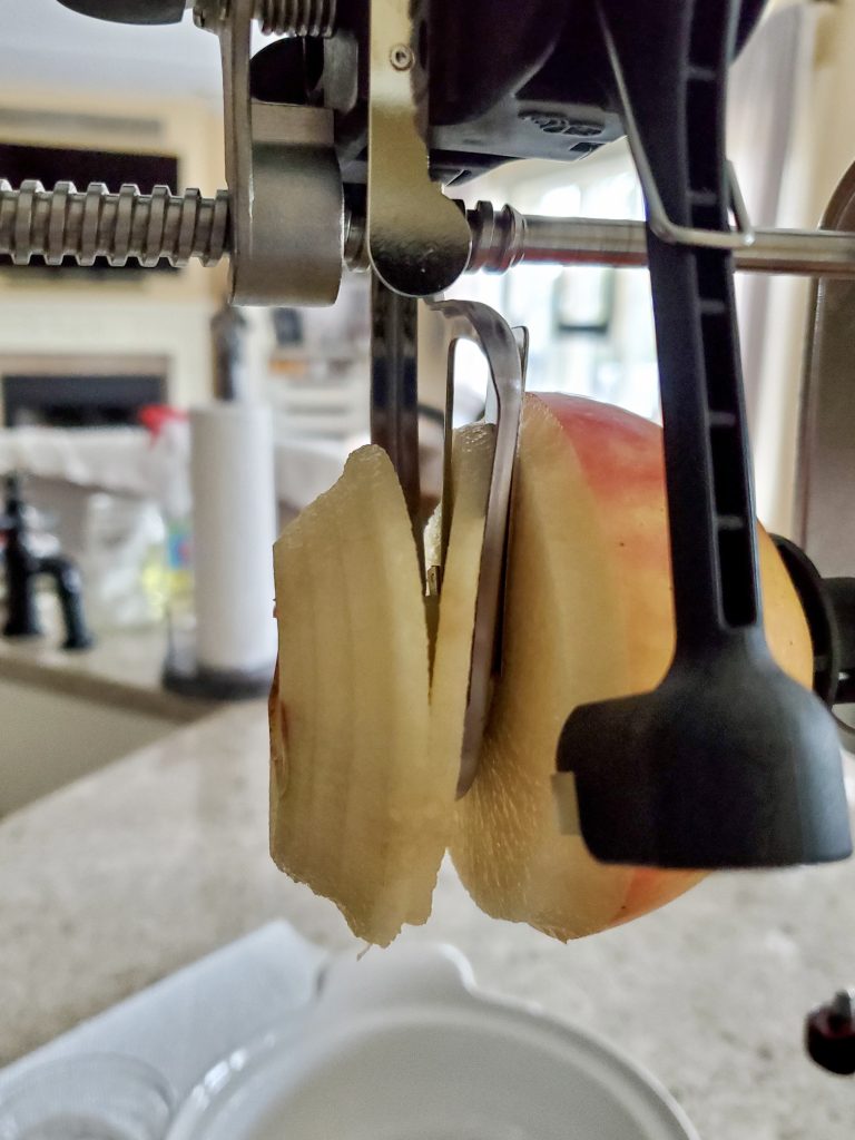 the apple being cored, peeled and sliced for the applesauce