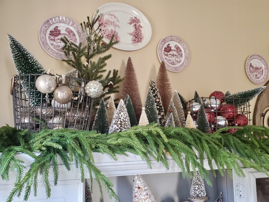 the hutch top filled with bottle brush trees, metal baksets and garland