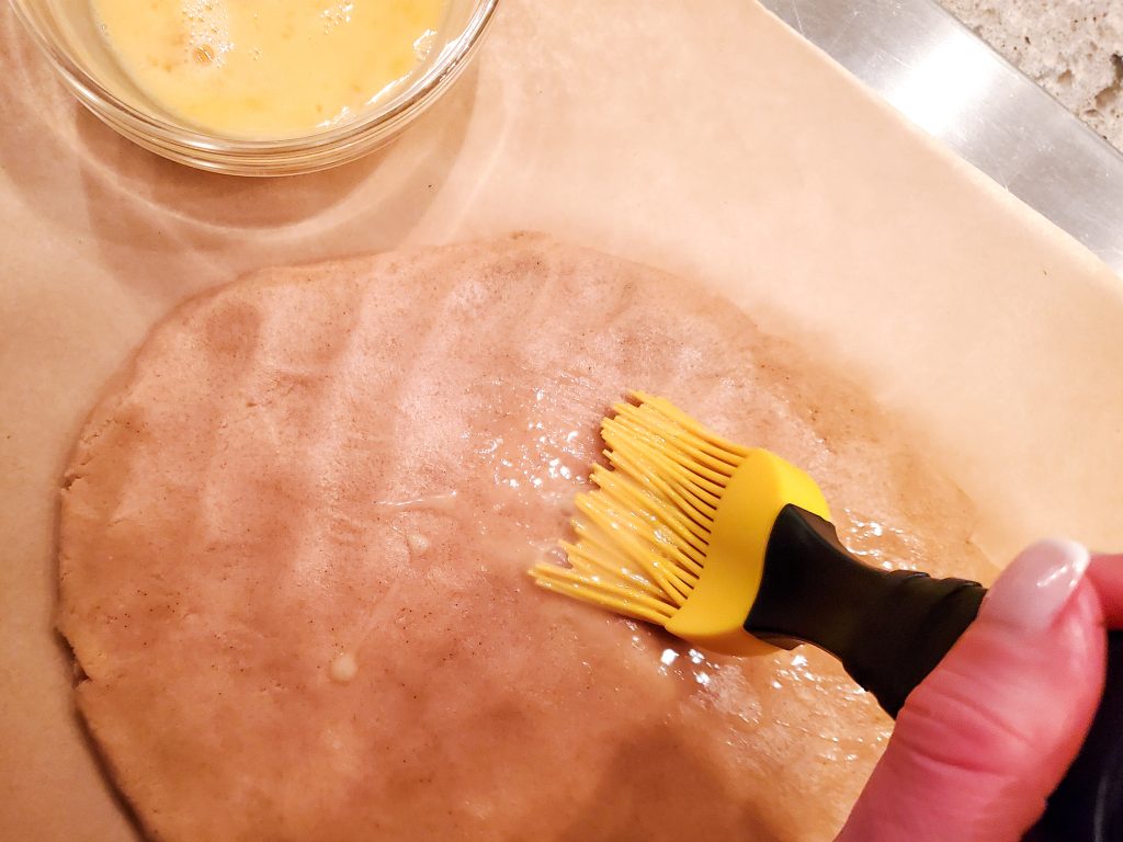 brush the beatedn egg on to the batter with a pastry brush
