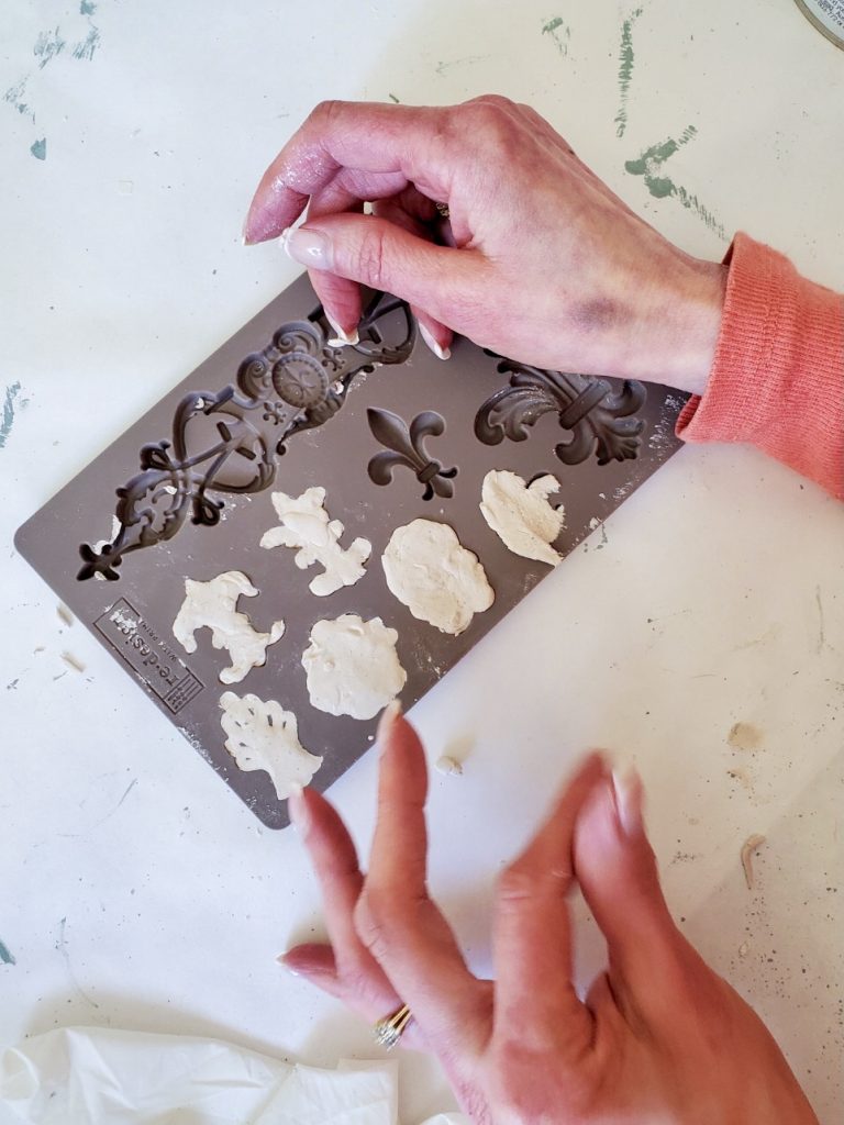 a picture of the clay getting added to the IOD mold for the Christmas balls