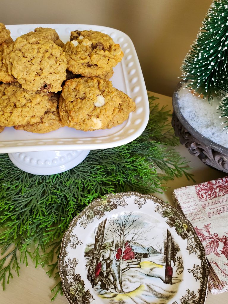 Finished cookies on a cake plate with small dishes and napkins