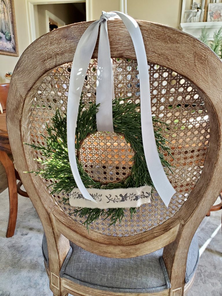clsoe up of the back of a dining room chair with a small wreath