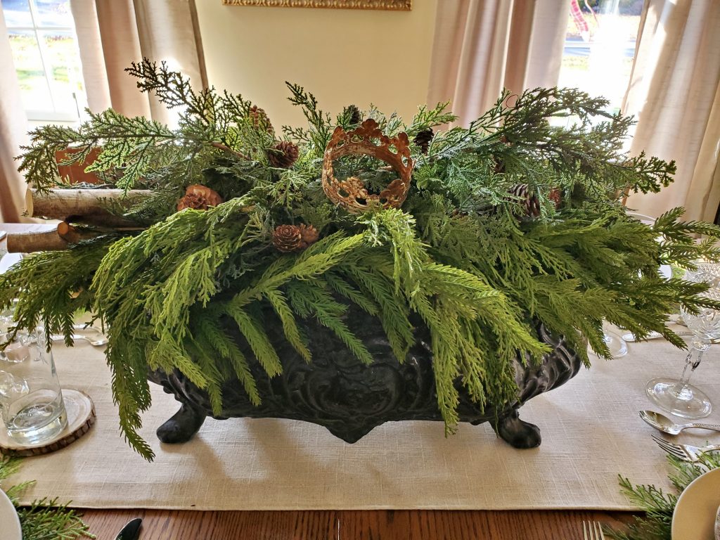 French jardiniere filled with greens, birch logs, pinecones and a crown