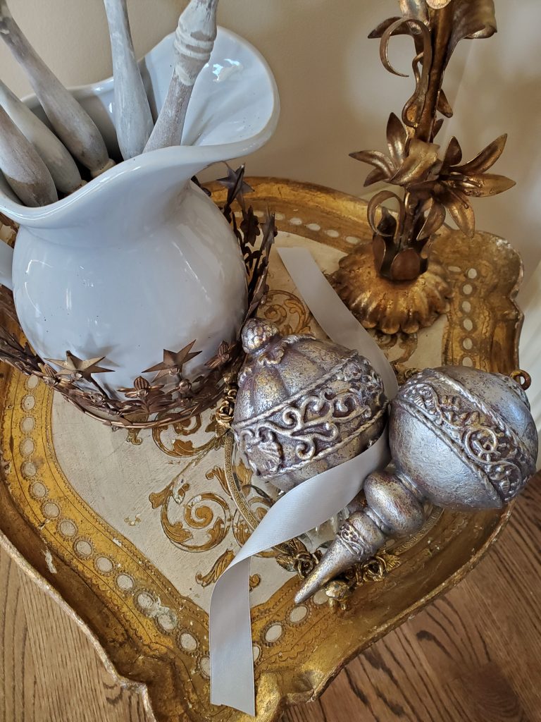 a picher inside a crown and antique ornaments with satin ribbon