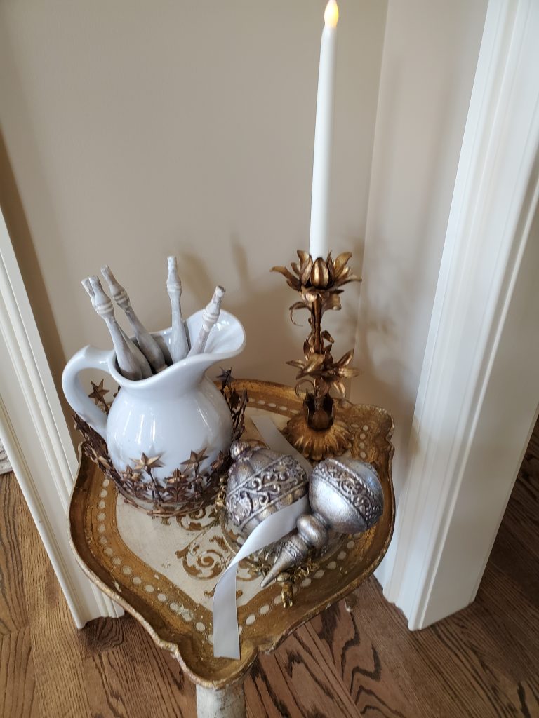 A loretine tabel with a candle and ornaments and a pitcher