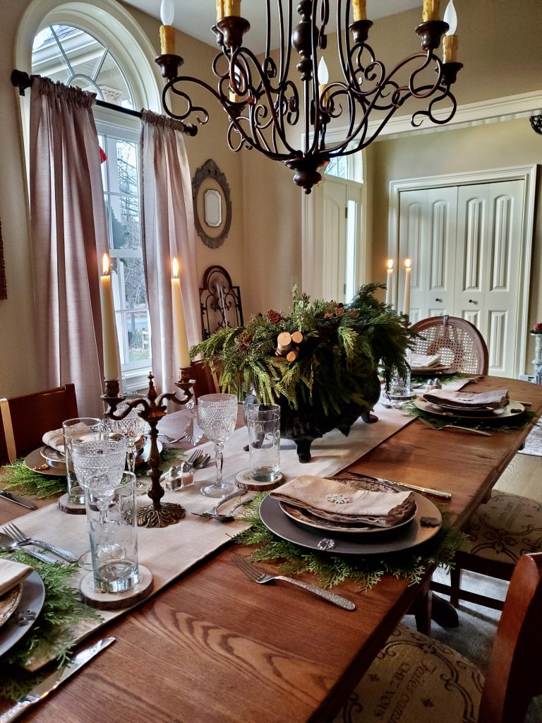 another angle of the christmas time in the dining room with candles lit and the table set