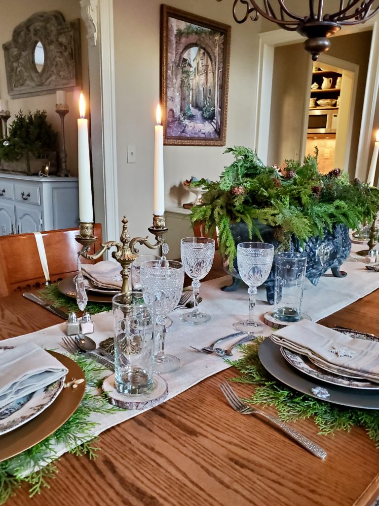 the dining room table with candles lity and showing the table set for christmas time in the dining room