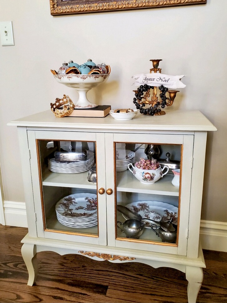 a close up of a small china cabinet in the christmas time dining room