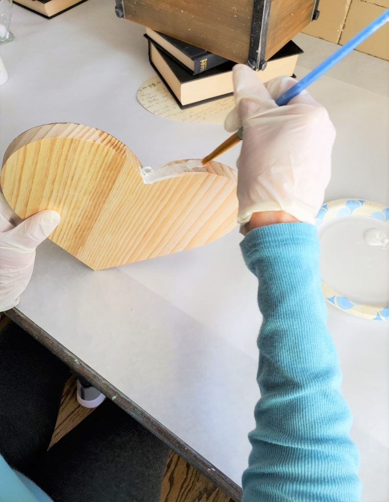 painting the sides of the wood heart with white paint