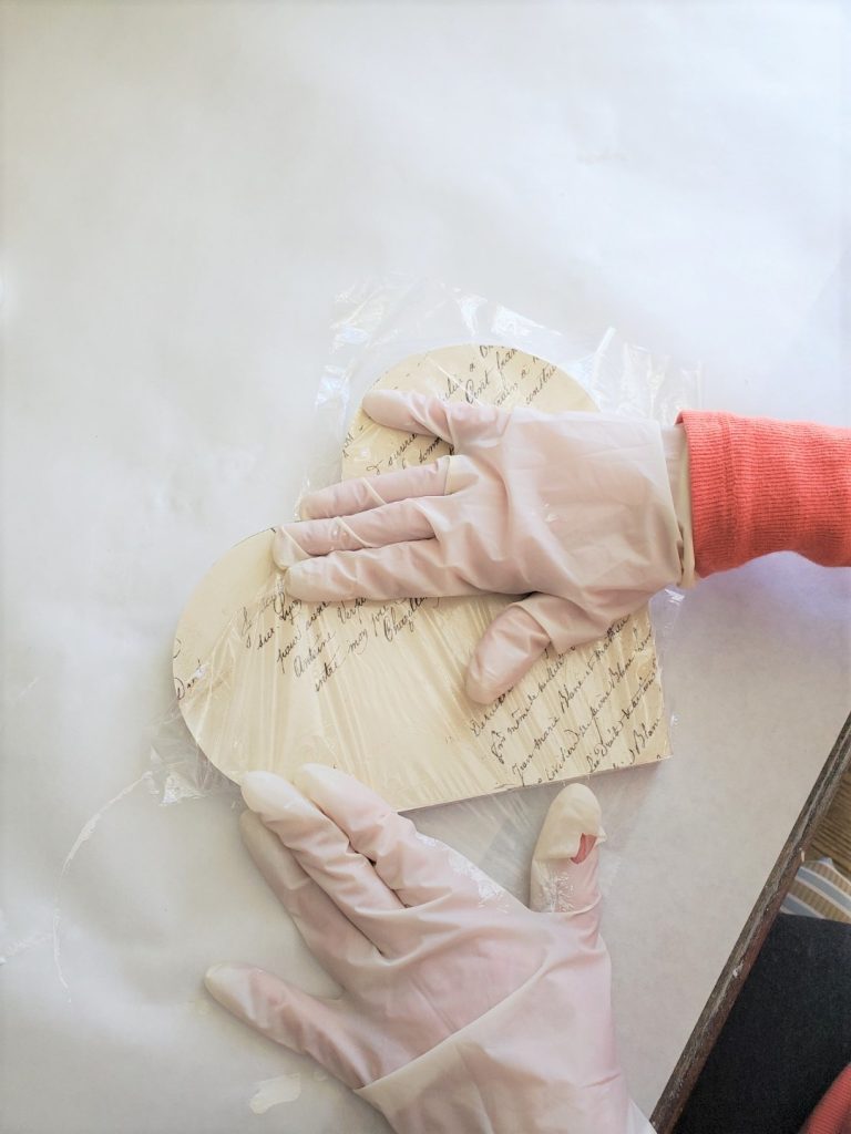rubbing the wrapping paper with plastic wrap to keep from wrinkling
