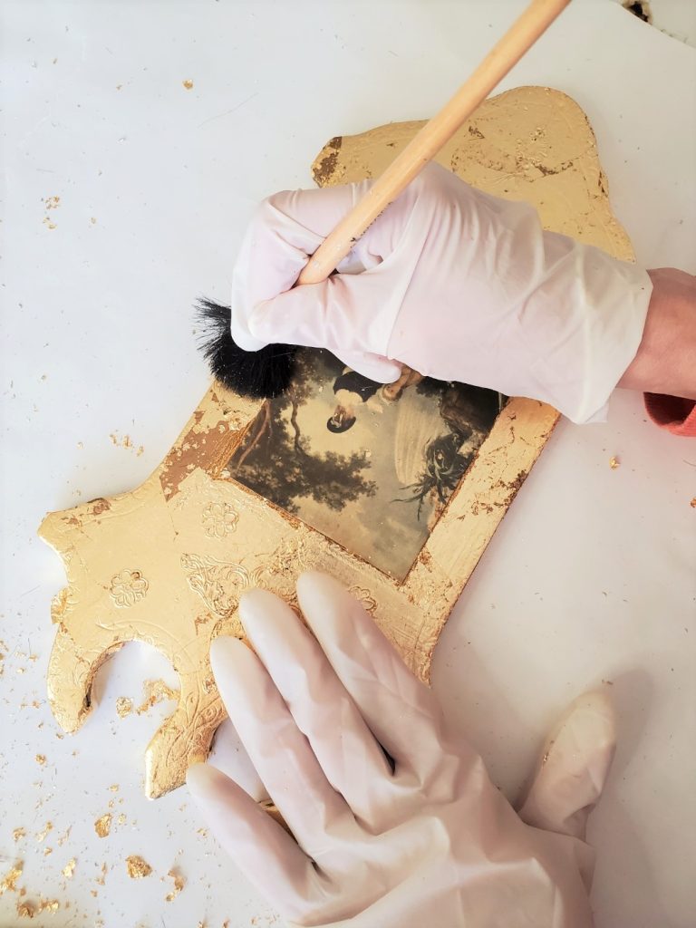 using a gilding brush to smooth the leaf