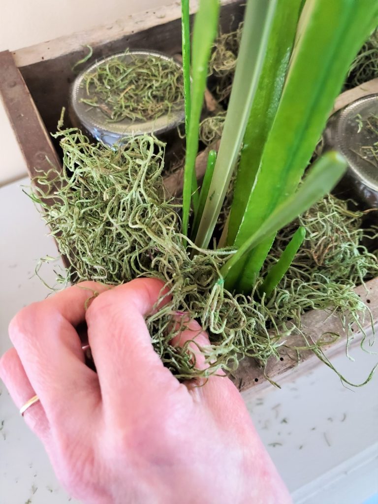 Adding more green Spanish moss to the centerpiece