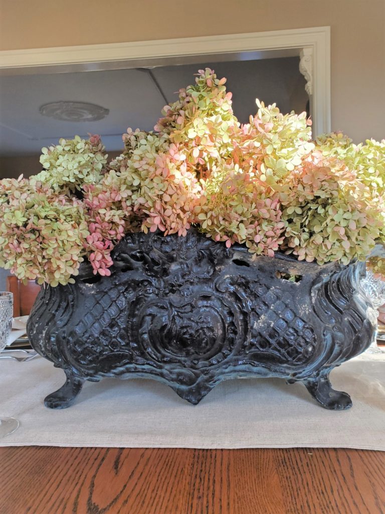 black jardiniere filled with dry hydrangeas