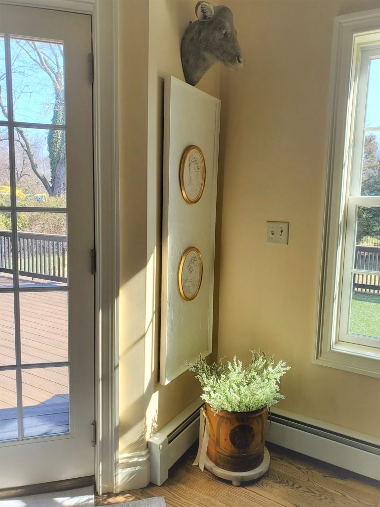 Adding Easy Spring Decorating in the Home with antique Florentine plaques and a bucket filled with white Heather 
