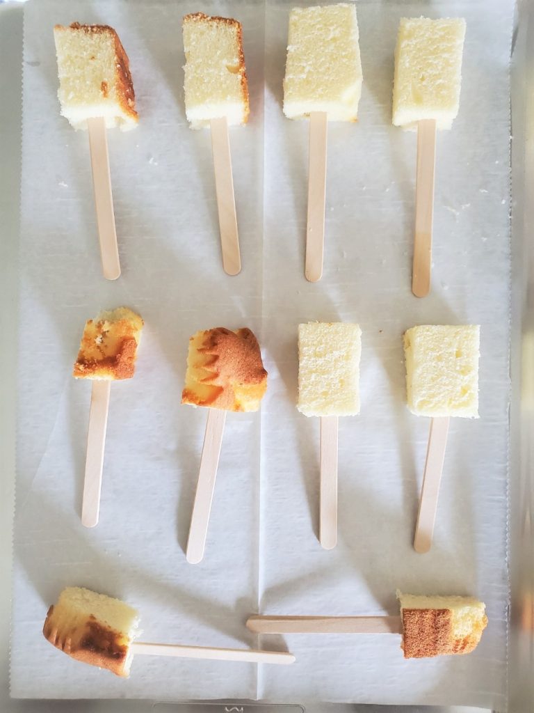 7 Easy Semi Homemade Easter Dessert Ideas pound cake on popsicle sticks laying on parchment paper