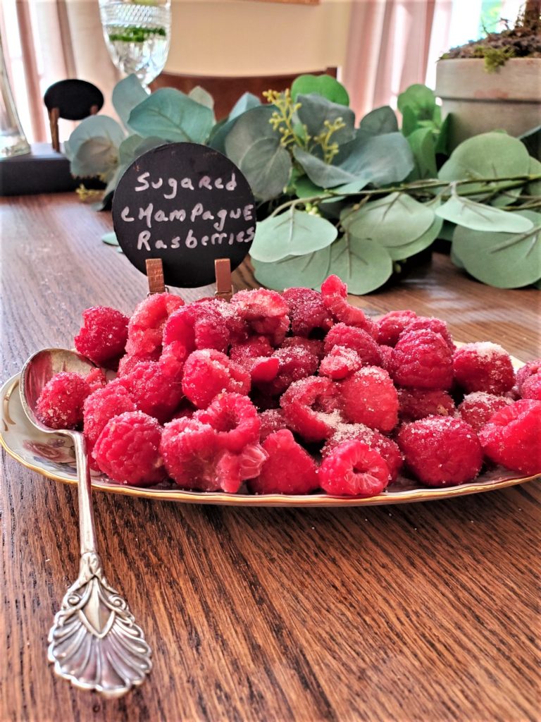 sugared champagne raspberries on a dish with an elegant spoon for the garden gathering